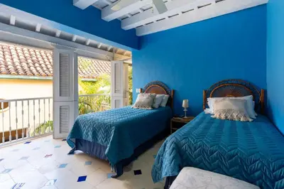 a blue bedroom with two beds and a balcony at Casa azul in Cartagena de Indias