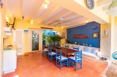 a dining room with a table and chairs and a couch at Casa azul in Cartagena de Indias