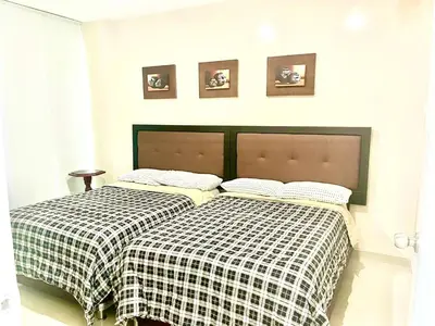 a bedroom with two beds with a checkered blanket at Hermoso apartamento MORROS EPIC in Cartagena de Indias