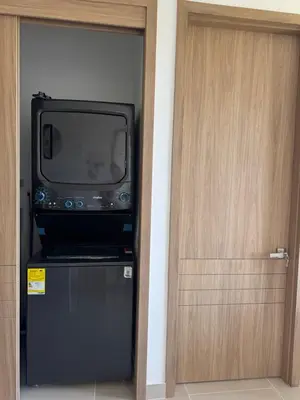 a tv sitting on top of a refrigerator next to a door at Baia Kristal 5I in Estación El Salto