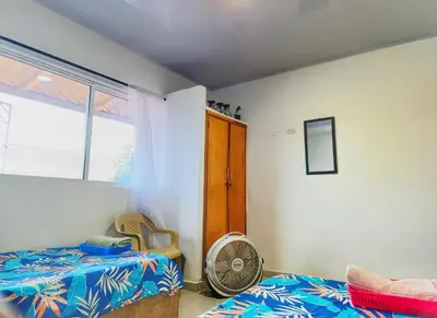 a bedroom with a bed and a fan and a window at Apartamento cerca a la playa in El Porvenir