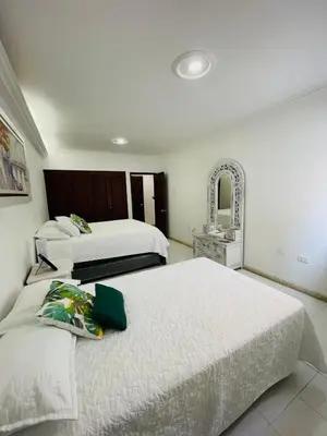 a hotel room with two beds and a mirror at Loft Vista al Laguito in Cartagena de Indias