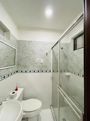 a white bathroom with a toilet and a shower at Loft Vista al Laguito in Cartagena de Indias