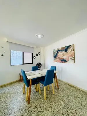a dining room with a table and blue chairs at Loft Vista al Laguito in Cartagena de Indias
