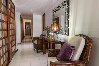 a living room with a chair and a table and a mirror at Apartamento frente al mar in Cartagena de Indias