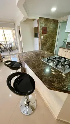a kitchen with a counter with two stools and a stove at Cabrero Beach 1213 in Cartagena de Indias