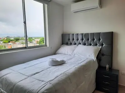 a bedroom with a large bed with a large window at Apartamento completo in Cartagena de Indias