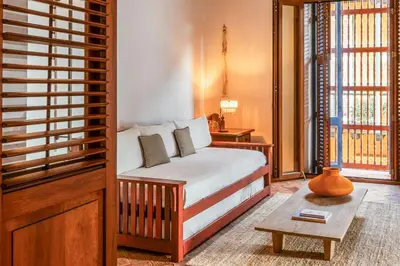 a bedroom with a bed and a table and windows at Casa Trujillo in Cartagena de Indias