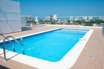 a swimming pool on the roof of a building at Apartamento completo con vista a la ciudad in Cartagena de Indias
