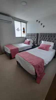 a bedroom with two beds with red and white sheets at Apartamento completo con vista a la ciudad in Cartagena de Indias