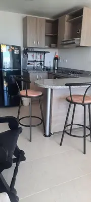 a kitchen with a table and two chairs and a counter at Apartamento completo con vista a la ciudad in Cartagena de Indias