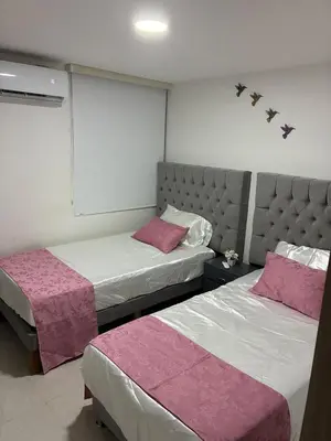 a bedroom with two beds with pink sheets at Apartamento completo con vista a la ciudad in Cartagena de Indias