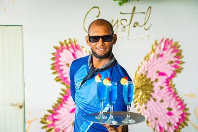 a man holding a tray with two drinks on it at Hostal barú in Bolivar