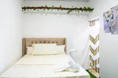 a small bedroom with a bed with a swan statue at Hostal barú in Bolivar