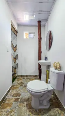 a bathroom with a toilet and a sink at Hostal barú in Bolivar