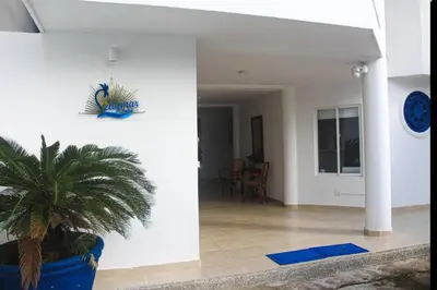 a living room with a plant in a blue pot at Chalet Ledymar in Cartagena de Indias