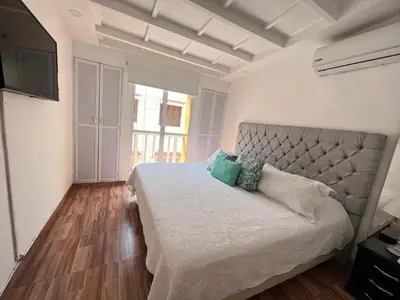 a bedroom with a large bed and a large window at Hermoso duplex en la ciudad amurallada! A218 in Cartagena de Indias