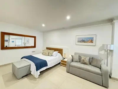 a bedroom with a bed and a couch at Hermoso apto estudio en la ciudad amurallada! in Cartagena de Indias
