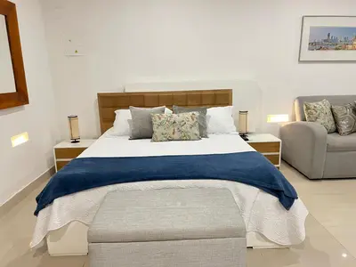 a bedroom with a large bed and a couch at Hermoso apto estudio en la ciudad amurallada! in Cartagena de Indias