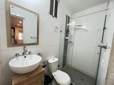 a bathroom with a sink and a toilet and a mirror at Hermoso apto estudio en la ciudad amurallada! in Cartagena de Indias