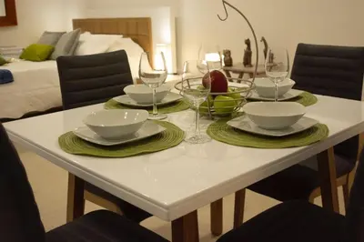 a white table with plates and wine glasses on it at Hermoso apto estudio en la ciudad amurallada! in Cartagena de Indias