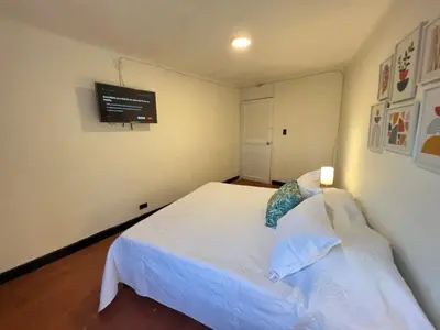 a bedroom with a white bed and a tv on the wall at Lovely Duplex with balcony! in Cartagena de Indias