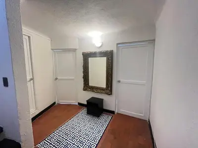 a hallway with a mirror on the wall next to two doors at Lovely Duplex with balcony! in Cartagena de Indias