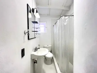a white bathroom with a toilet and a sink at Lovely Duplex with balcony! in Cartagena de Indias