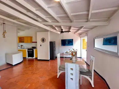 a dining room with a table and a kitchen at Lovely Duplex with balcony! in Cartagena de Indias