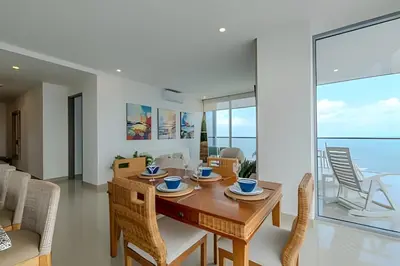 a dining room and living room with a table and chairs at Beachfront Penthouse 40th Sea View/Historic Center in Cartagena de Indias