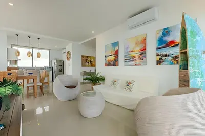 a living room with two white chairs and a table at Beachfront Penthouse 40th Sea View/Historic Center in Cartagena de Indias