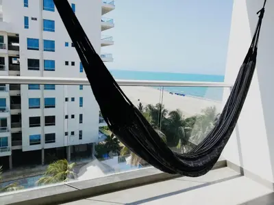 a hammock on a balcony with a view of the beach at Apartamento con vista directa al mar en Spiaggia di Cartagena in Cartagena de Indias
