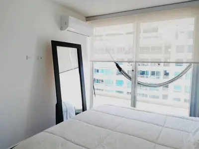 a bedroom with a white bed and a large window at Apartamento con vista directa al mar en Spiaggia di Cartagena in Cartagena de Indias