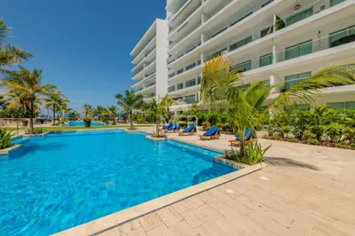 a swimming pool in front of a building at Morros Epic 2 Bedrooms Beachfront by Inmobiliaria MFR in Cartagena de Indias