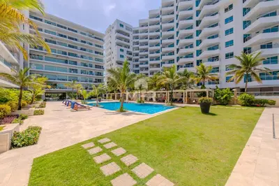 a large apartment building with a pool and palm trees at Morros Epic 2 Bedrooms Beachfront by Inmobiliaria MFR in Cartagena de Indias