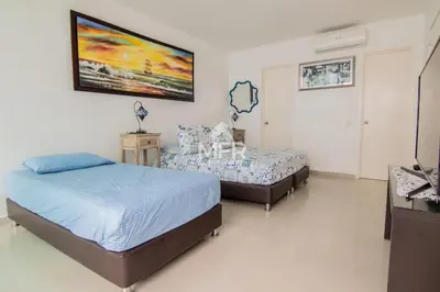 a bedroom with two beds and a tv in it at Morros Epic 2 Bedrooms Beachfront by Inmobiliaria MFR in Cartagena de Indias