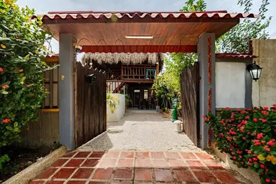 an entrance to a house with a wooden pergola at cabaña villa luz in Santa Veronica