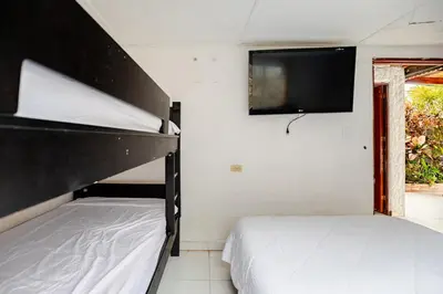 two beds in a bedroom with a tv on the wall at cabaña villa luz in Santa Veronica