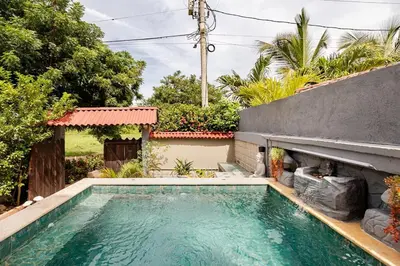 a swimming pool in front of a house at cabaña villa luz in Santa Veronica