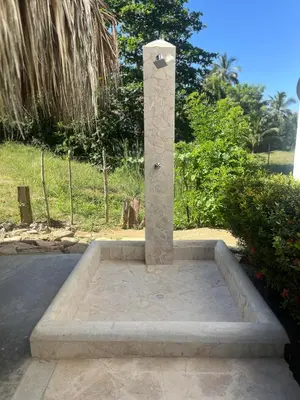 a stone fountain in a park with trees in the background at Hotel Heliopolis in Coveñas