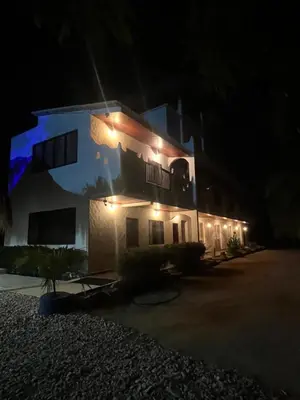 a house with lights on the side of it at night at Hotel Heliopolis in Coveñas