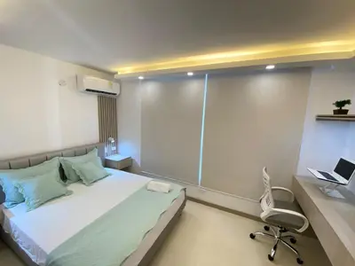 a bedroom with a bed and a desk and a laptop at Terrazas Vista al Mar y Piscina Espectacular in Cartagena de Indias