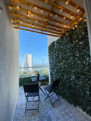 a patio with two chairs and a table and a wall at Terrazas Vista al Mar y Piscina Espectacular in Cartagena de Indias