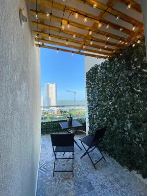 a patio with two chairs and a table and a wall at Terrazas Vista al Mar y Piscina Espectacular in Cartagena de Indias