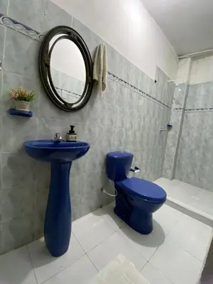 a bathroom with a blue toilet and a mirror at Casa alojamiento entero - cerca al castillo san Felipe in Cartagena de Indias