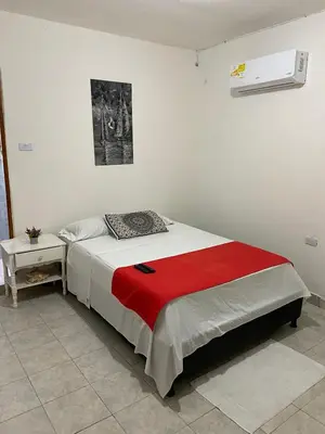 a bedroom with a bed with a red blanket at Casa alojamiento entero - cerca al castillo san Felipe in Cartagena de Indias