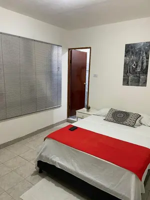 a bedroom with a large bed with a red blanket at Casa alojamiento entero - cerca al castillo san Felipe in Cartagena de Indias