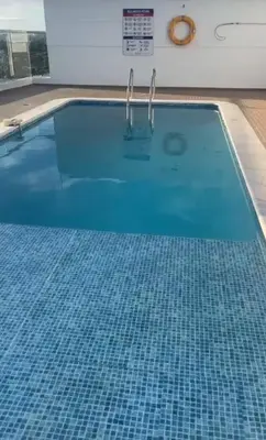 a large swimming pool with blue tiles on the floor at Apartamento con balcón grande in Cartagena de Indias