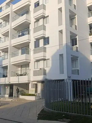 a white building with a fence in front of it at Apartamento con balcón grande in Cartagena de Indias