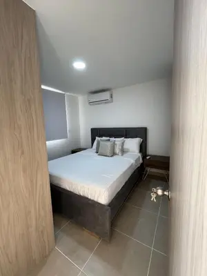 a bedroom with a bed with white sheets and pillows at Apartamento con balcón grande in Cartagena de Indias